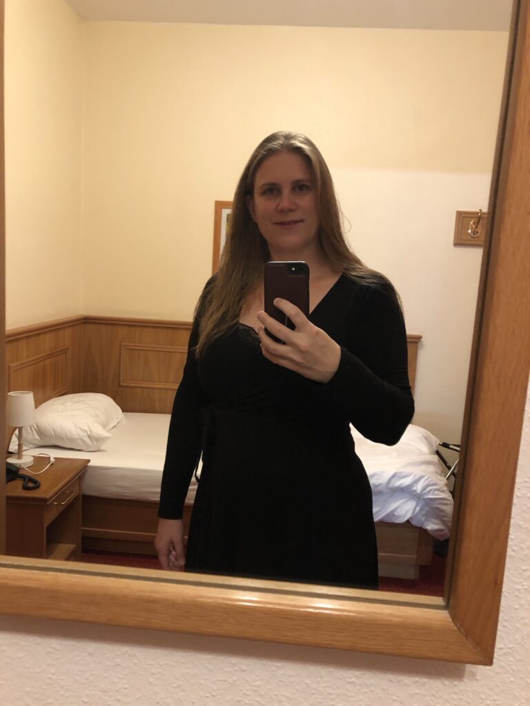 Ein Foto von mir im Spiegel des Hotelzimmers im schwarzen Kleid. 