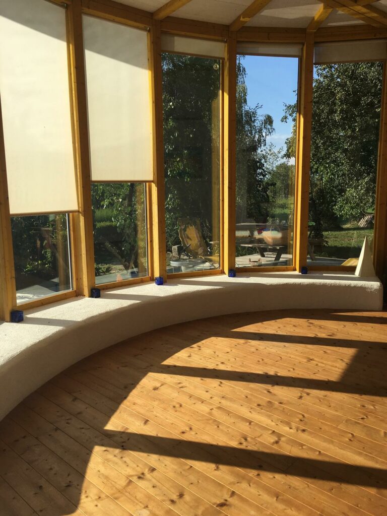 ein runder Raum mit einer Verglasung, Blick in die Natur, Holzboden