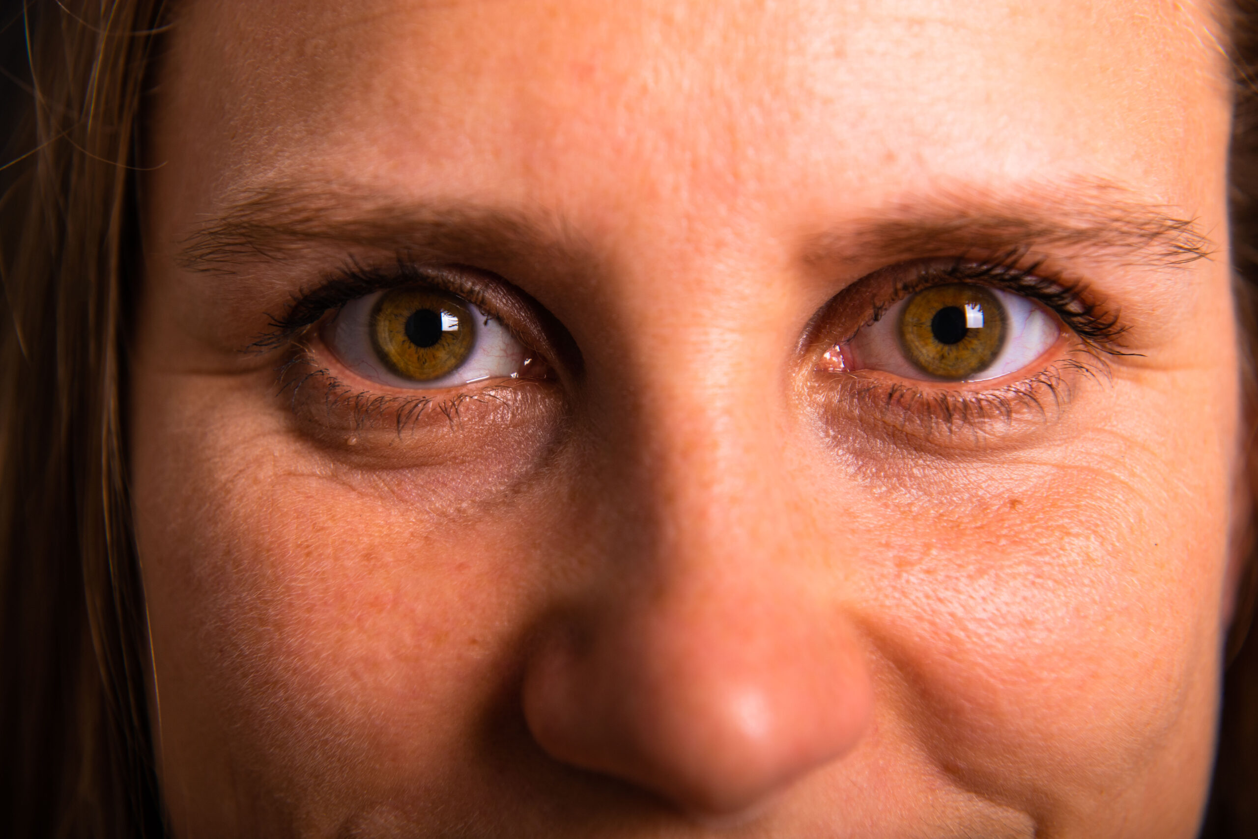 Nahaufnahme von den Augen einer Frau, die direkt und offen blickt. Ein Symbol fürs Mensch sein und sich als ganzer Mensch zeigen.