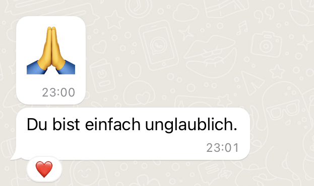 In einem WhatsApp-Chat wird ein Emoji mit betenden Händen angezeigt, dann eine Nachricht auf Deutsch mit dem Text „Du bist einfach unglaublich.“ gefolgt von einem Emoji mit rotem Herz.