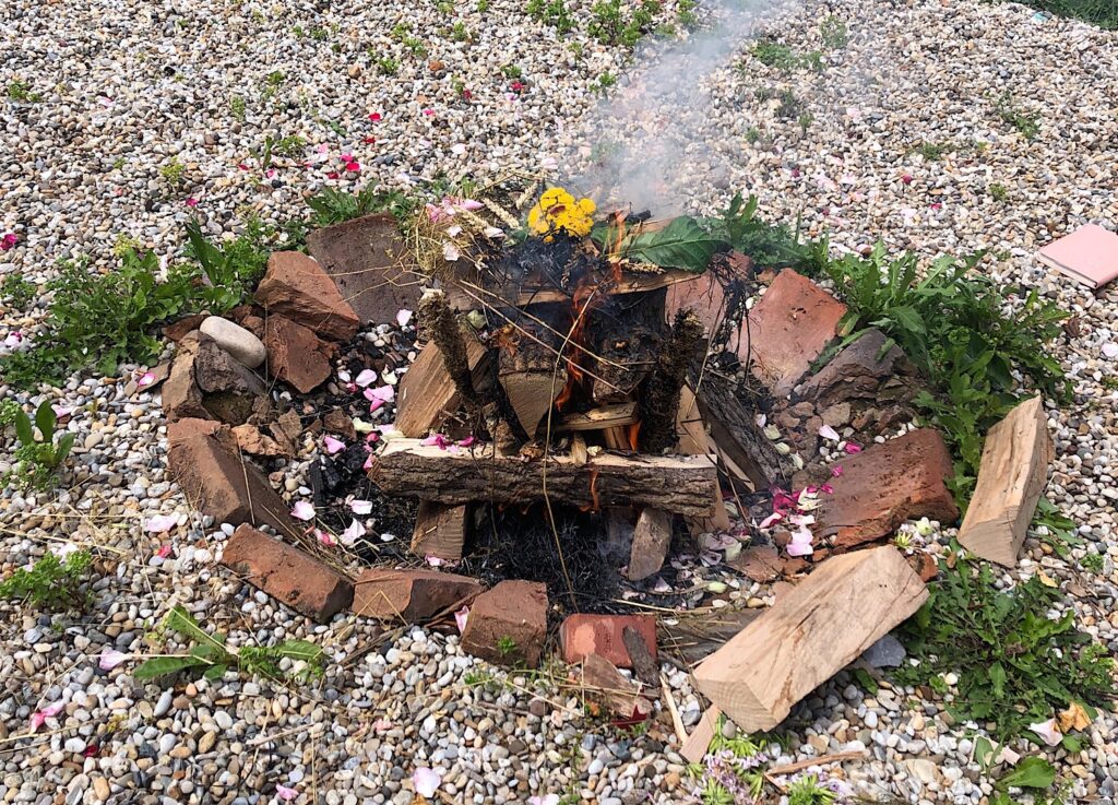 Ein aufgebautes Lagerfeuer bzw. zeremonielles Feuer mit Kräutern und Blumen.