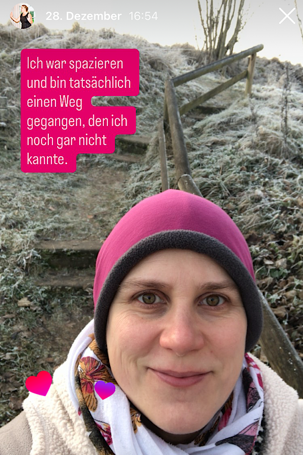 Generose auf einem Selfie mit einer pinken Mütze. Im Hintergrund vereiste Winterlandschaft und steile Stufen mit einem Geländer. Auf dem Bild steht: "Ich war spazieren und bin tatsächlich einen Weg gegangen, den ich noch gar nicht kannte."